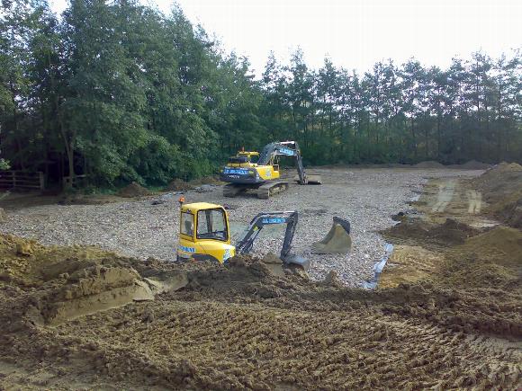 two construction vehicles performing groundworks 