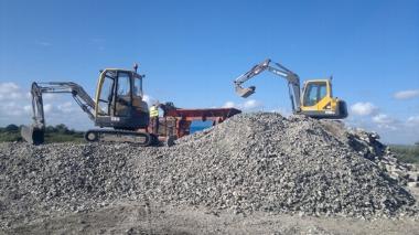 two large diggers on a mound of rubble on a building site
